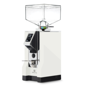 Vinklet billede af Eureka Mignon Perfetto kaffekværn i hvid med firkantet bønnebeholder og digitalt display. Det minimalistiske hvide design med farverig grind-indikator understreger dens moderne og funktionelle stil.