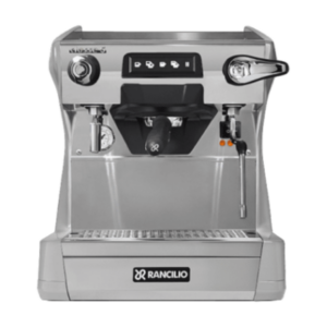 Rancilio Classe 5 USB Tall - 1 gruppe. Selve maskinen er af rustfrit stål, så den har en sølv farve. Gruppehovedet er sort og det samme er knapperne. Gruppehovedet sidder i midten, steamarmen i højre side, vand udtrak til venstre.
