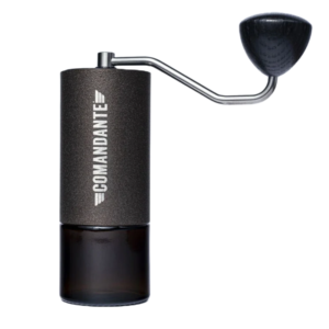 Kværnens krop er lavet af rustfrit stål og er belagt med en struktureret farvefinish kaldet "Copper Mountain." Den har en robust, men alligevel elegant kobberfarvet overflade, der både er holdbar og modstandsdygtig overfor slid. Håndtaget er fastgjort til toppen af kværnen og er lavet af rustfrit stål med en træknop i mørkt træ. Det er formet ergonomisk, hvilket giver et godt greb under brug. Træknoppen på håndtaget har en glat overflade, og den sorte farve står flot i kontrast til kobberfinishen. På forsiden af kværnens krop er der et tydeligt "Comandante"-logo indgraveret i sølv, hvilket tilføjer et eksklusivt touch til kværnens look. Nederst på kværnen sidder en aftagelig glasbeholder, hvor de malede kaffebønner opsamles. Denne glaskop er mørkebrun, næsten sort i farven, hvilket bidrager til det minimalistiske og moderne udseende.