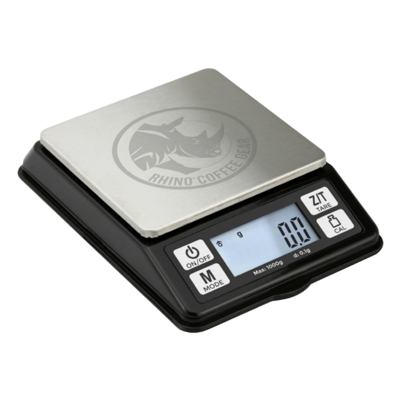 Rhino Coffee Gear kaffevægt med digitalt display og rustfri stålplade, der har Rhino-logo indgraveret. Vægten viser præcise målinger i gram og har knapper til tænd/sluk, tarefunktion og måleenhed.