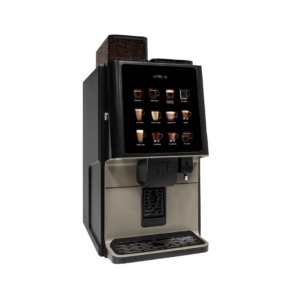 Billedet viser kaffemaskinen Azkoyen Vitro X1, som er en moderne og stilfuld maskine til professionelle miljøer. Maskinen har en sort og bronze-farvet konstruktion med en intuitiv touchskærm, der viser forskellige drikkevalg som espresso, cappuccino, latte, chokolade og mere. En kompakt kaffekværn er synlig i toppen, hvilket tilføjer et premium udtryk. Maskinen har en central dispenser og en drypbakke i rustfrit stål, som gør rengøring nem.