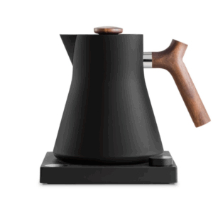 Sort elektrisk kedel med træhåndtag og låg af valnød på en minimalistisk base, perfekt til præcis te- og kaffebrygning.