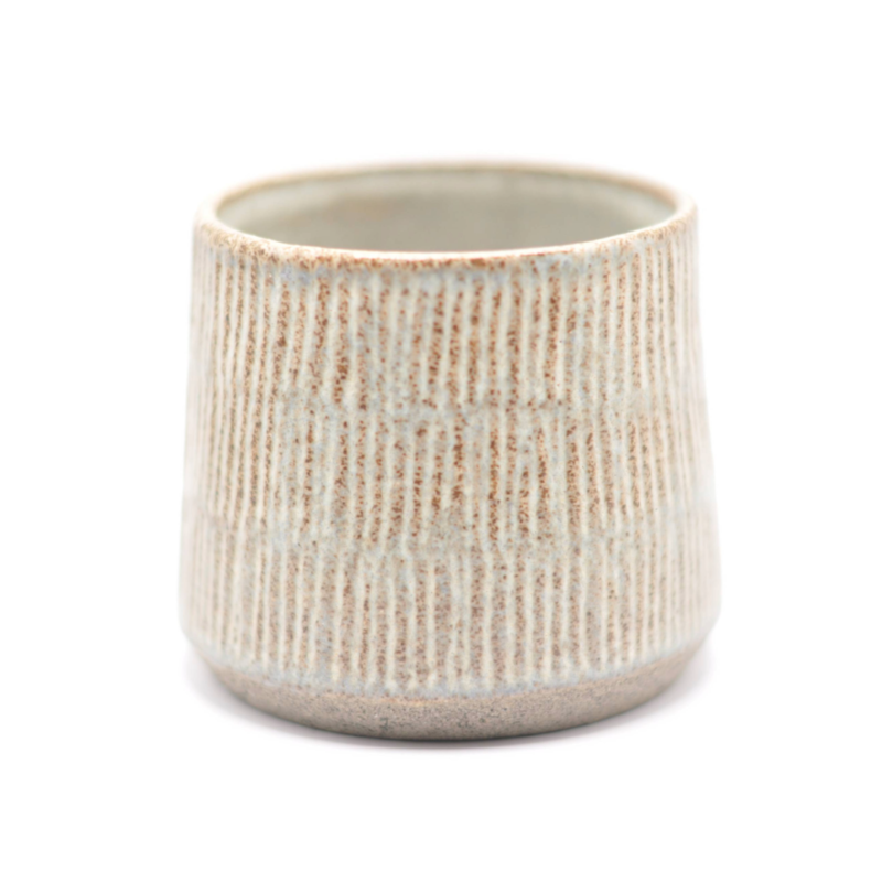 En stilren blå keramikkop med smalle riller, fremhævet af en rå keramisk tekstur.