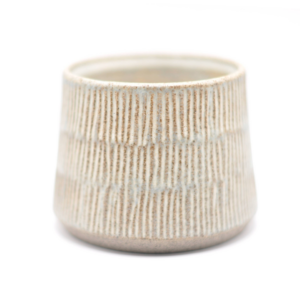 En håndlavet blå keramikkop med smalle riller og en glasurlignende finish.