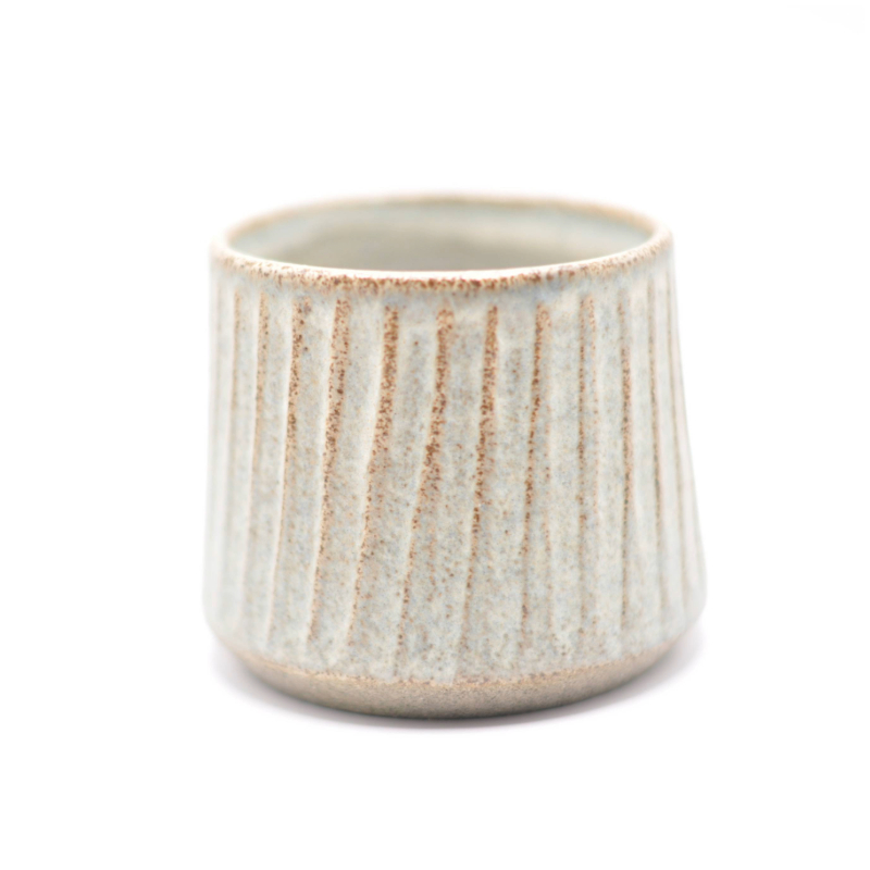 En enkelt blå keramikkop med brede riller, som viser koppen i sin helhed.