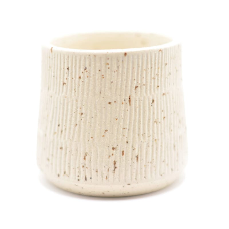 En håndlavet beige keramikkop med smalle riller fra "Hva' ler du af".