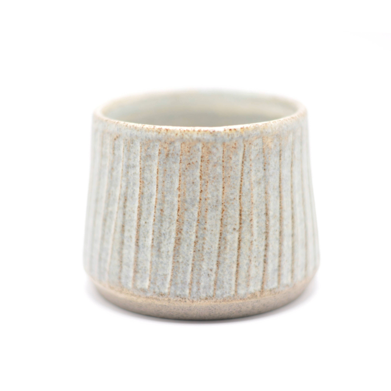 En enkelt blå keramikkop med brede riller, som viser koppen i sin helhed.