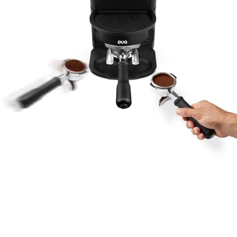 En barista placerer et portafilter i PUQpress M3 tamper, som er designet til at passe perfekt under en espressokværn.