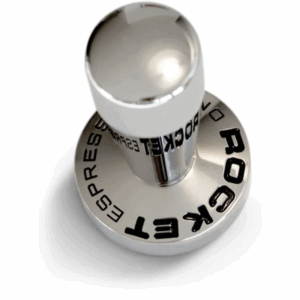 En Rocket tamper i poleret rustfrit stål med et ergonomisk greb. Bunden er bred og flad for optimal kaffekomprimering, og "Rocket Espresso" er indgraveret med sort tekst rundt om basen. Designet kombinerer elegance og funktionalitet til espressobrygning
