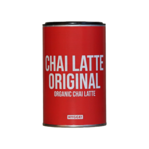 En rød dåse med HYGGE Chai Latte Original med tydelig hvid skrift. Økologisk chai latte-pulver til en varm og krydret drik med hygge-stemning.