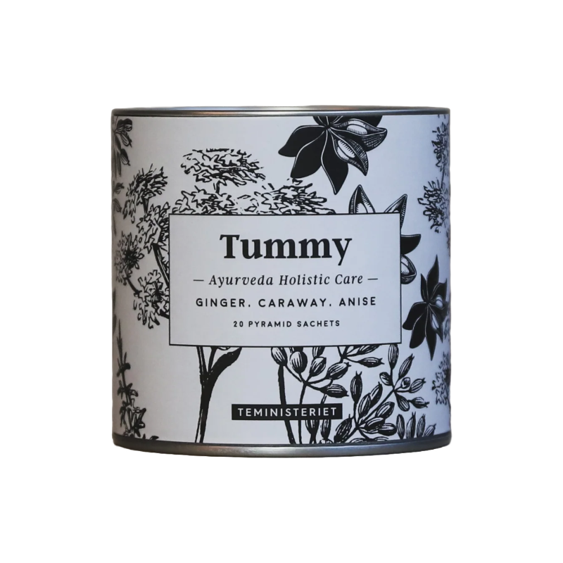 Teministeriet Ayurveda Tummy te i en rund, cylinderformet metaldåse med samme botaniske design som papæsken. Dåsen har en sort-hvid illustration af urter og krydderier, blandt andet anis og ingefær, der omkranser etiketten med produktnavnet "Tummy". Under dette står "Ayurveda Holistic Care" samt ingredienserne: ingefær, kommen og anis. Derudover er det angivet, at dåsen indeholder 20 pyramide-tebreve. Designet har en ren og naturlig æstetik, der signalerer velvære og fordøjelsesfremmende egenskaber.