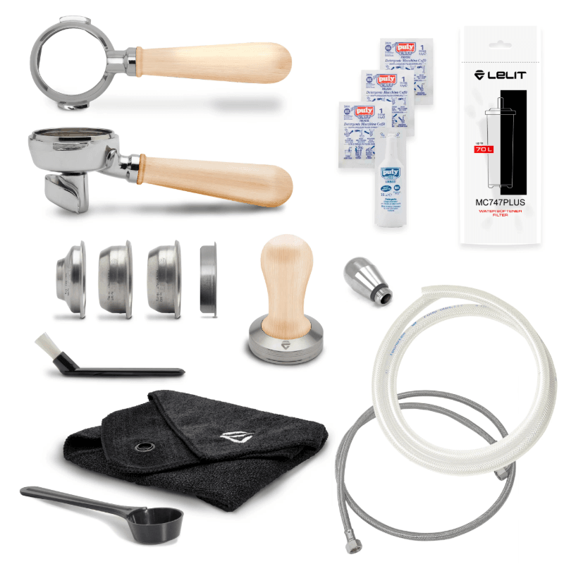 Tilbehør til Lelit Bianca espressomaskine med lyst træhåndtag – filterkurve, tamper, rensebørste, filter og slanger.