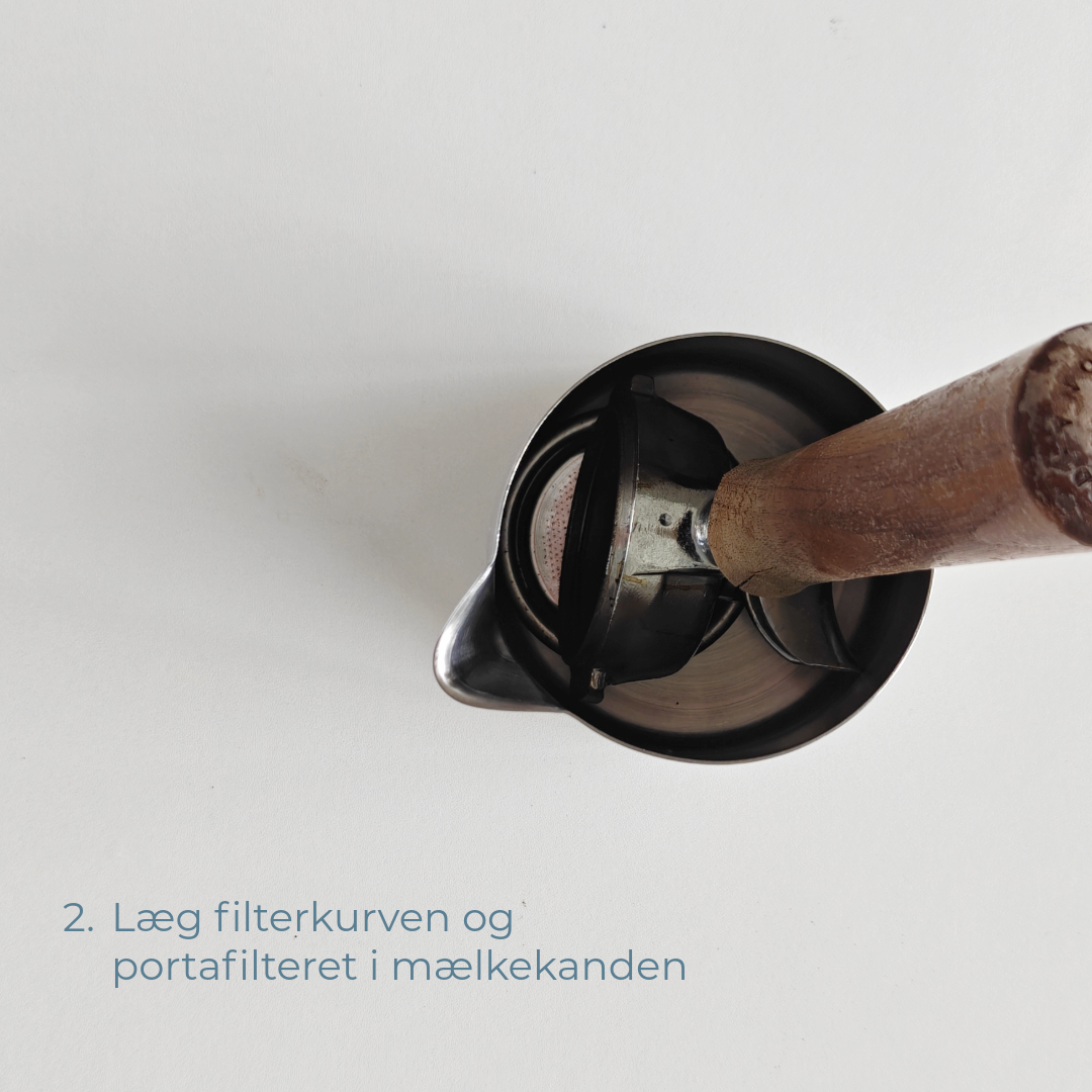 Filterkurv og portafilter placeret i en mælkekande.