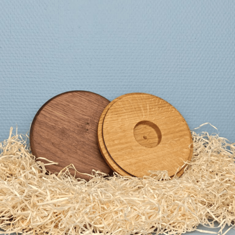 Bagside af låg i eg med udfræsning, ved siden af et låg i valnød, omgivet af træuld.