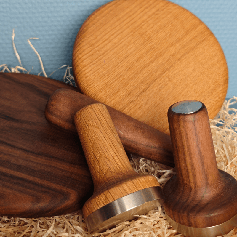 Kaffetilbehør fra Baark i eg og valnød: låg og tampere samlet i træuld.