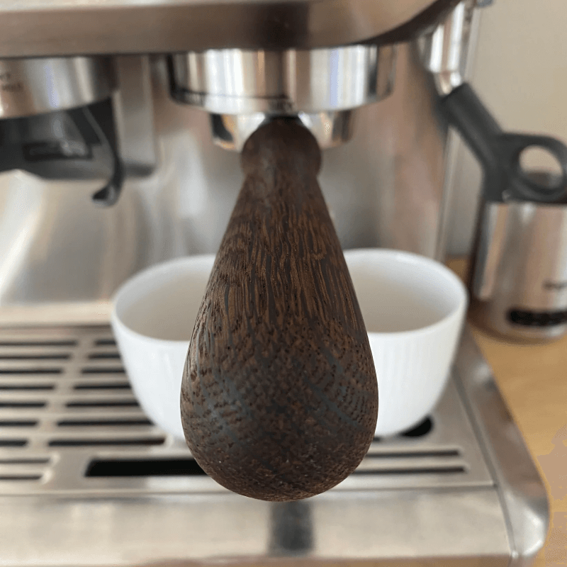 Portafilter i valnød monteret på Sage espressomaskine, nærbillede af håndtagets ende.