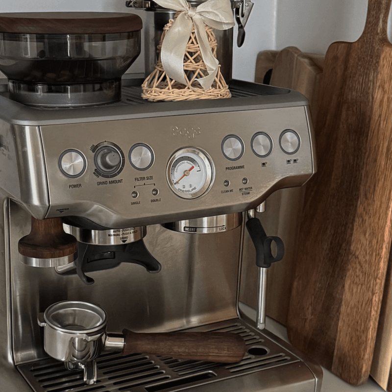 Baark The Sage Tamper i valnød – placeret på espressomaskine sammen med portafilter og kaffekværn.