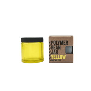 Comandante bønnebeholder i gul med sort låg. Til højre står beholderen i dens emballage med skriften "Polymer Bean Jar Yellow"