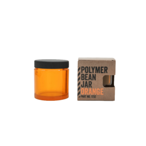 Comandante bønnebeholder i orange med sort låg. Til højre står beholderen i dens emballage med skriften "Polymer Bean Jar Orange"