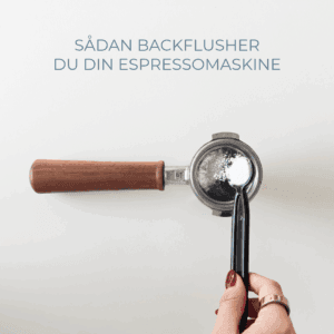 Portafilter med træhåndtag, hvor der tilsættes espressorens med ske – tekst: "Sådan backflusher du din espressomaskine".