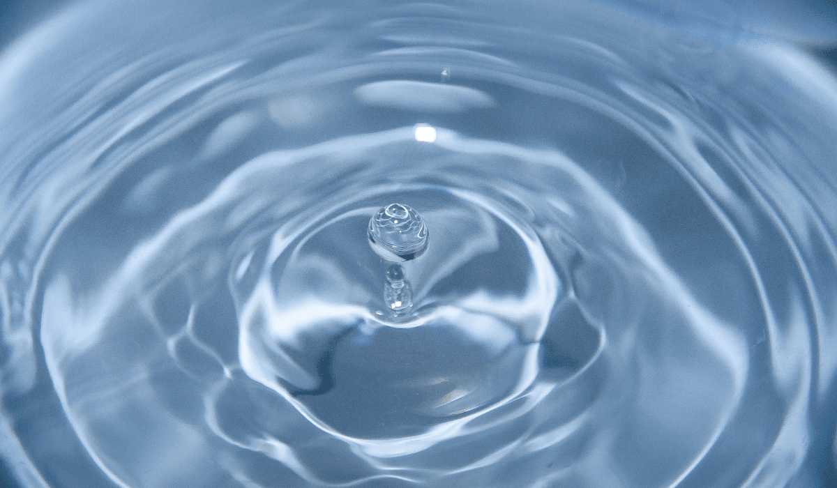 Billede af vand hvor en dråbe er ved at lande i midten a nogle vandringe