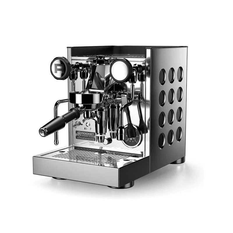 Rocket Appartamento espressomaskine fotograferet i skrå front-side vinkel; fokus på gruppehoved, dampstav og det perforerede sidepanel — elegant, kompakt design i rustfrit stål.