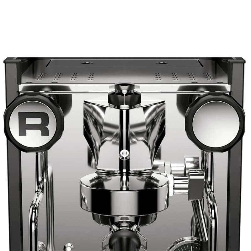 Nærbillede af gruppehoved på Rocket Appartamento med portafilter, steamarm og analogt manometer; detaljer i poleret stål og præcise, mekaniske komponenter synlige.