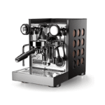 Rocket Appartamento TCA - Sort/Kobber espressomaskine set i skrå frontalvinkel med portafilter monteret, manometer, dampstav og perforeret sidepanel med kobberindsatser; poleret front og detaljer i krom, kompakt professionelt design.