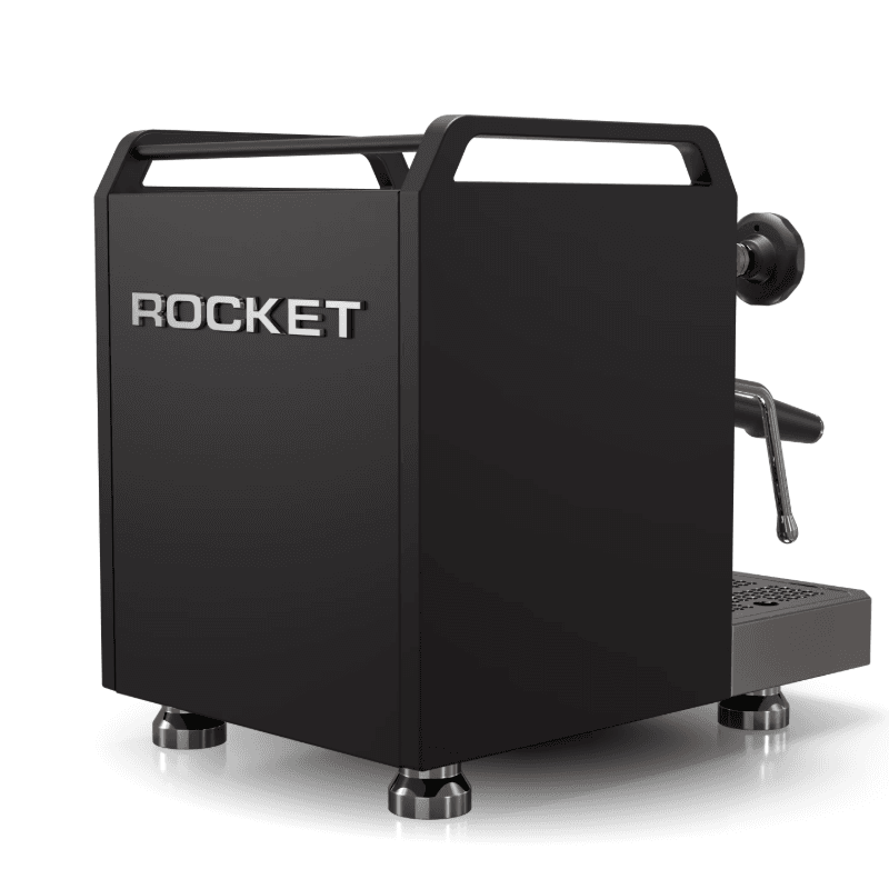 Rocket Mozzafiato Fast R espressomaskine set bagfra i trekvartvinkel med synligt ROCKET-logo og mat sort sidepanel; kromtop, robuste fødder og dampstav synlig i profil.