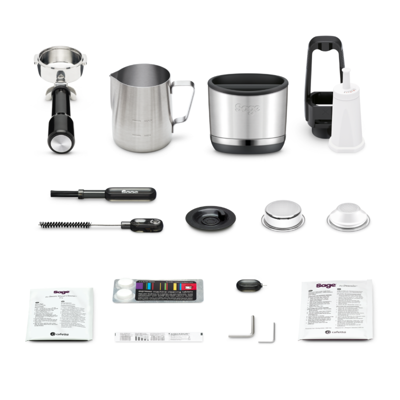 Medfølgende tilbehør til Sage Oracle Dual Boiler lagt ud på bordet: portafilter, mælkekande, dozer og renseværktøj — alt hvad du skal bruge til professionel brygning hjemme.