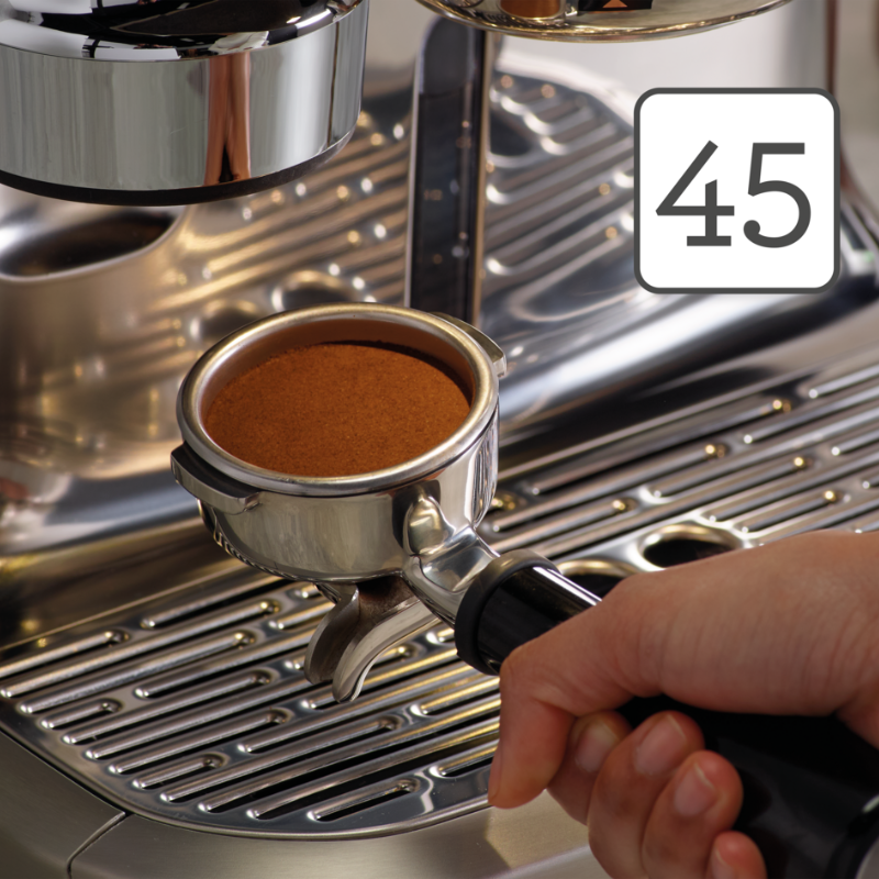 Nærbillede af portafilter med tampet kaffe i Sage Oracle Dual Boiler – viser korrekt puck-størrelse og jævn overflade før brygning.