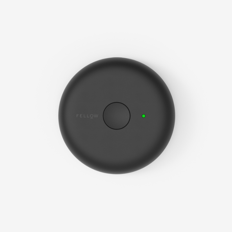 Atmos låg, topbillede — Topvisning af det sorte Atmos-vakuumlåg med central trykknap og lille grøn LED.